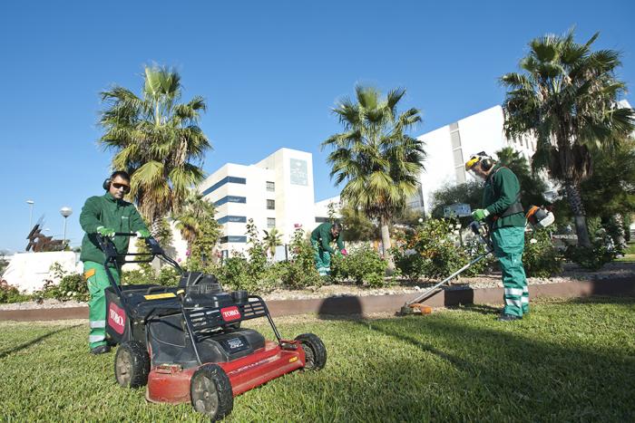Deux jardiniers du Grupo SIFU tondre l'herbe dans un espace vert